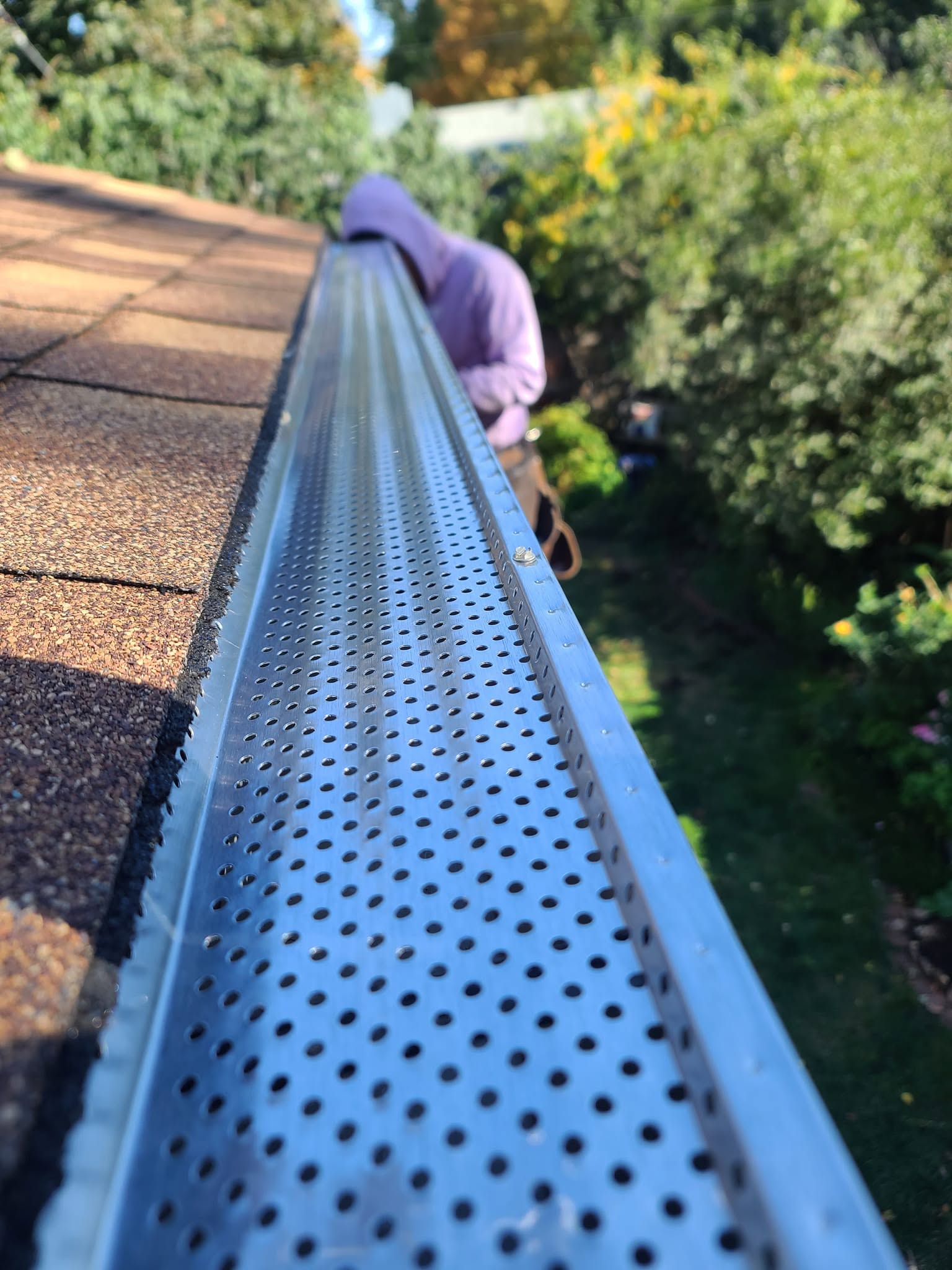 United Roofing & Siding close-up of gutter guard installation on a residential shingle roof in Sioux Falls, SD
