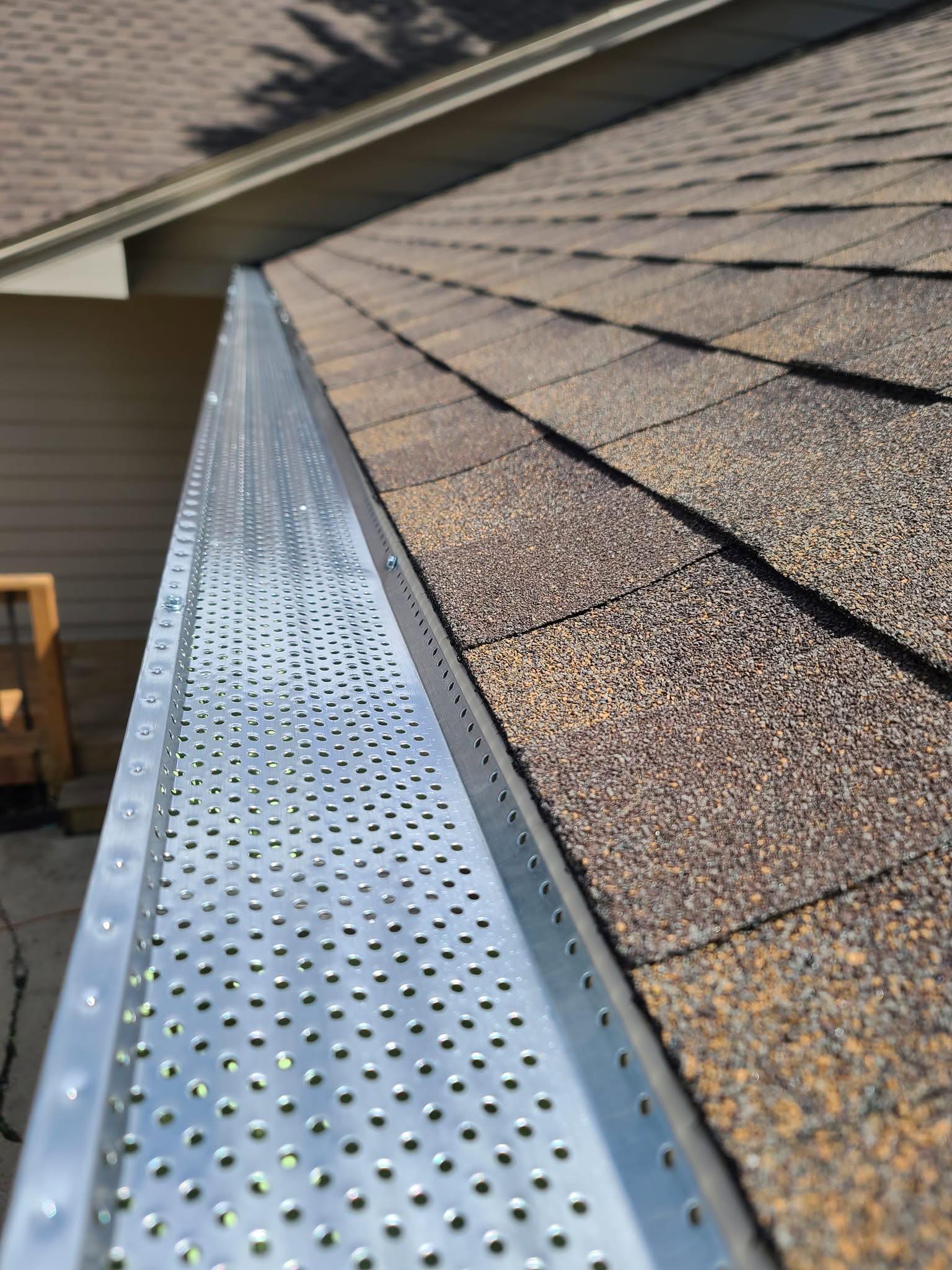 United Roofing & Siding gutter guard installation along a residential shingle roof in Sioux Falls, SD