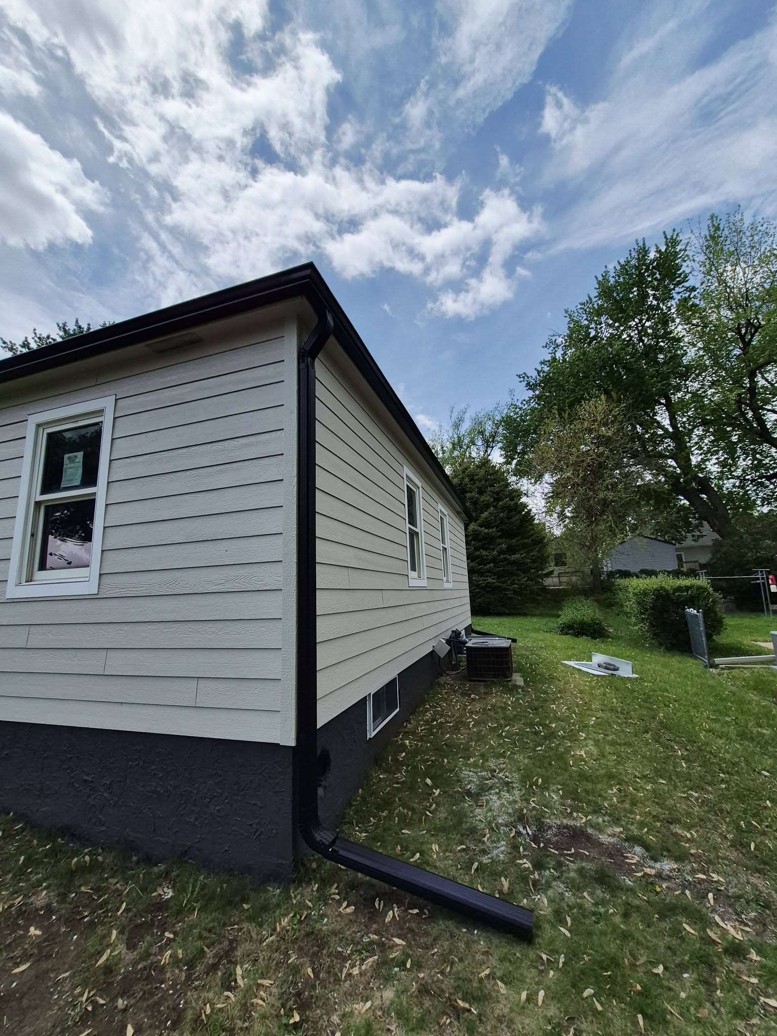 United Roofing & Siding residential siding with black downspout installation in Sioux Falls, SD